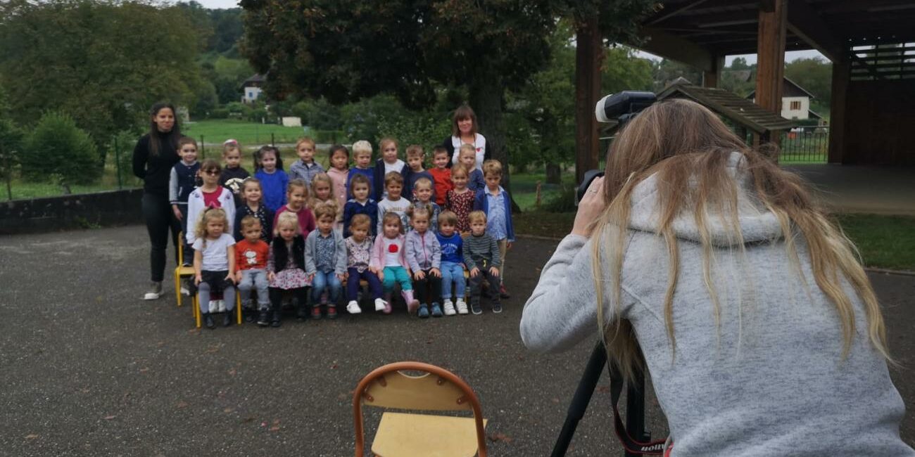 La photographe, Fanny Dumaine, intervient dans une école. Les élèves et les enseignantes sont placés pour la photo.