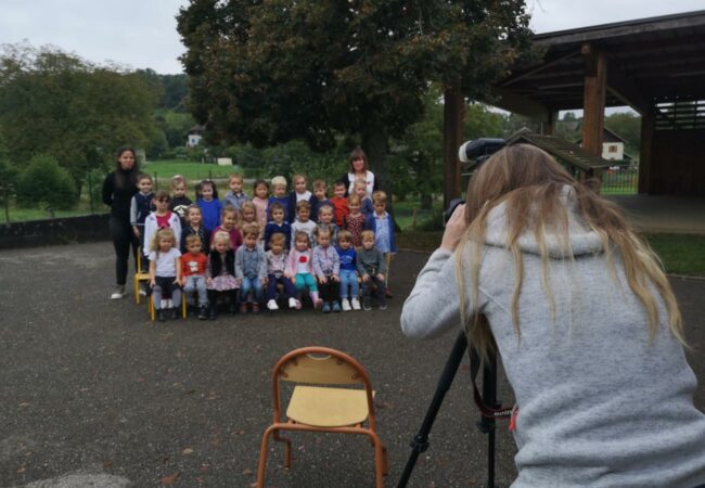 La photographe, Fanny Dumaine, intervient dans une école. Les élèves et les enseignantes sont placés pour la photo.