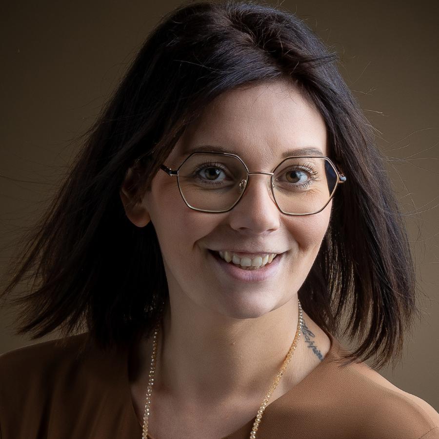 Portrait d’une jeune femme à lunettes. Portait d'une jeune femme brune avec des lunettes, un tatouage dans le cou et un collier en perles.